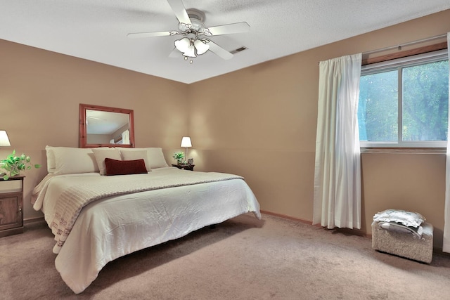 bedroom with a ceiling fan, baseboards, visible vents, a textured ceiling, and carpet flooring