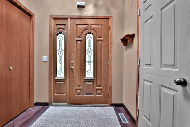 entrance foyer with dark wood-style floors, visible vents, and baseboards