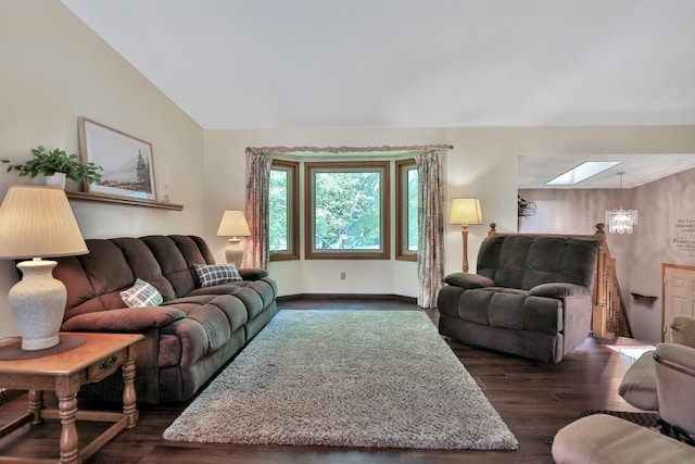 living area with baseboards, vaulted ceiling with skylight, and dark wood-type flooring