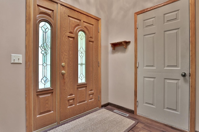 foyer featuring dark wood-style floors, visible vents, and baseboards