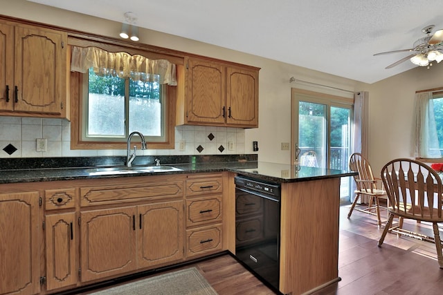 kitchen featuring dark wood-style floors, a peninsula, a sink, black dishwasher, and brown cabinets