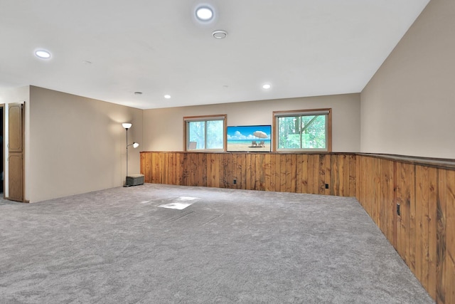 carpeted spare room featuring recessed lighting, a wainscoted wall, and wood walls