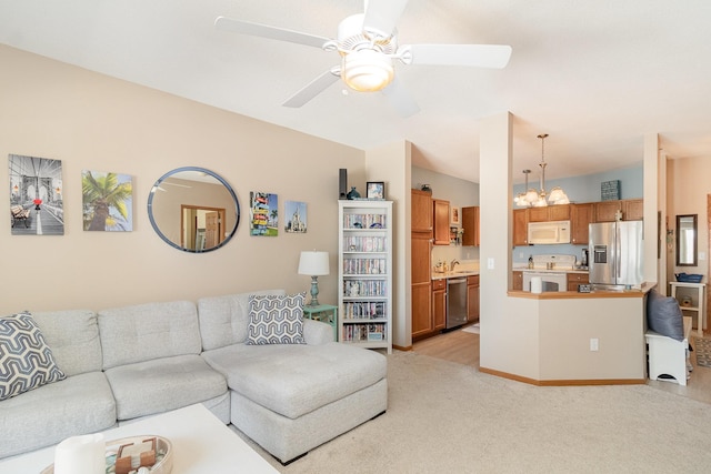 living room featuring lofted ceiling, light carpet, and ceiling fan with notable chandelier