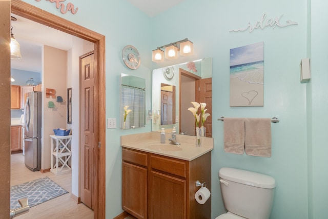 full bath with vanity, wood finished floors, and toilet