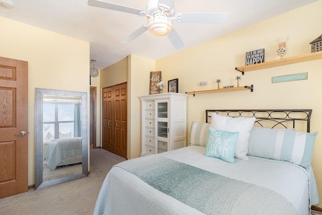 carpeted bedroom with ceiling fan and a closet