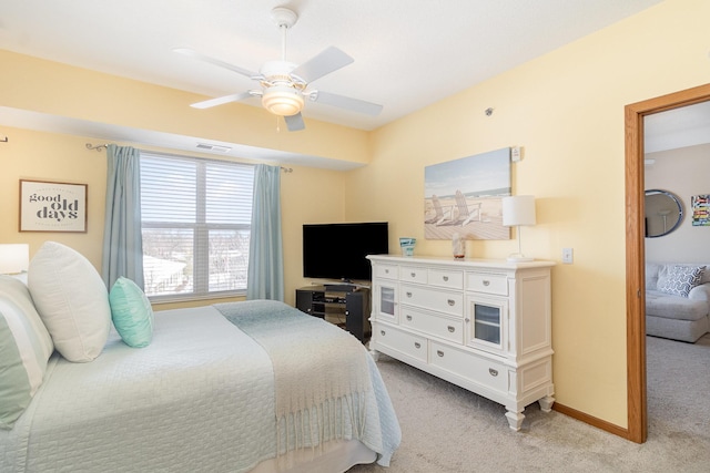 bedroom with light carpet, ceiling fan, visible vents, and baseboards