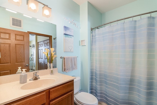 bathroom featuring visible vents, vanity, toilet, and a shower with curtain