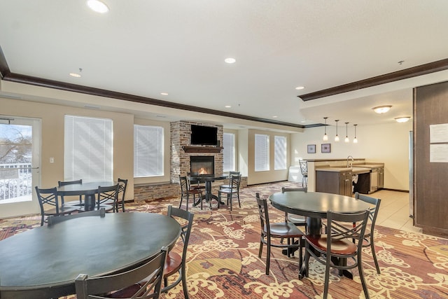 dining area with light tile patterned floors, recessed lighting, baseboards, ornamental molding, and a brick fireplace