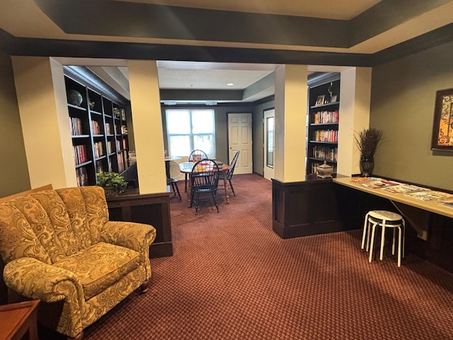 office with carpet floors, a tray ceiling, and built in features