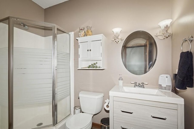 full bathroom featuring vanity, a shower stall, and toilet