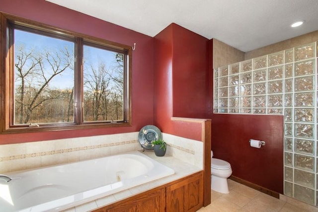 bathroom with tile patterned floors, toilet, and a bath