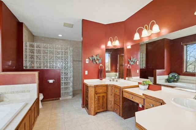 full bath featuring tile patterned flooring, walk in shower, toilet, a garden tub, and vanity