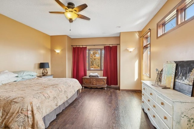 bedroom featuring dark wood finished floors, multiple windows, baseboards, and a textured ceiling