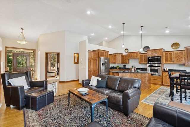 living area with recessed lighting, light wood-style floors, and high vaulted ceiling