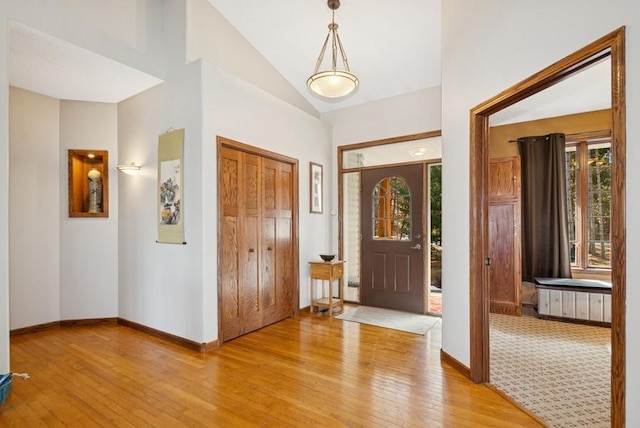 entrance foyer with baseboards, a healthy amount of sunlight, and light wood finished floors