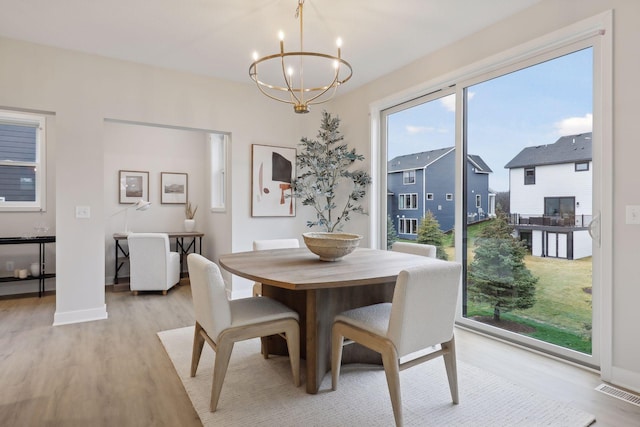 4640 Meadowview Ln, Minnetrista, MN 55331 - dining space with a chandelier and light wood-style flooring