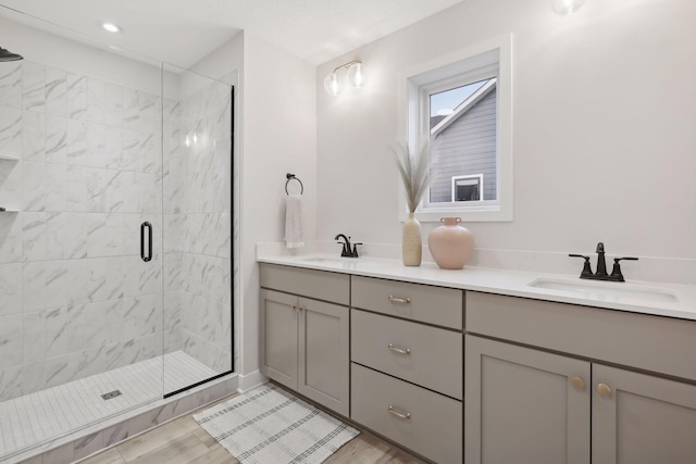 4640 Meadowview Ln, Minnetrista, MN 55331 - bathroom with double vanity, a shower stall, wood finished floors, and recessed lighting