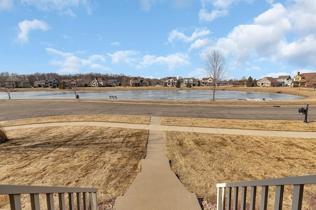 view of yard featuring a residential view and a water view