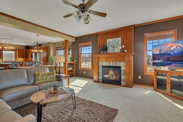 living room with a glass covered fireplace, a textured ceiling, light colored carpet, and ornamental molding