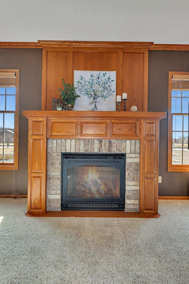 interior details featuring a brick fireplace, carpet flooring, and baseboards