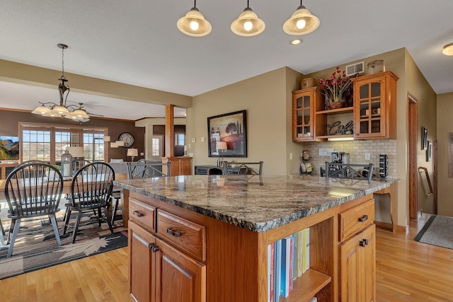 kitchen with open shelves, brown cabinetry, visible vents, and light wood finished floors