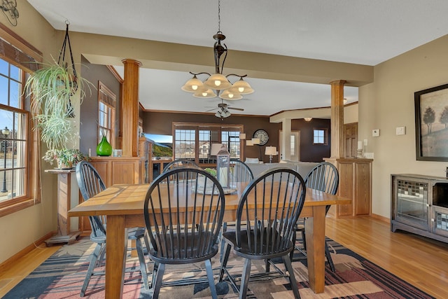 dining room with decorative columns, wood finished floors, baseboards, and ceiling fan