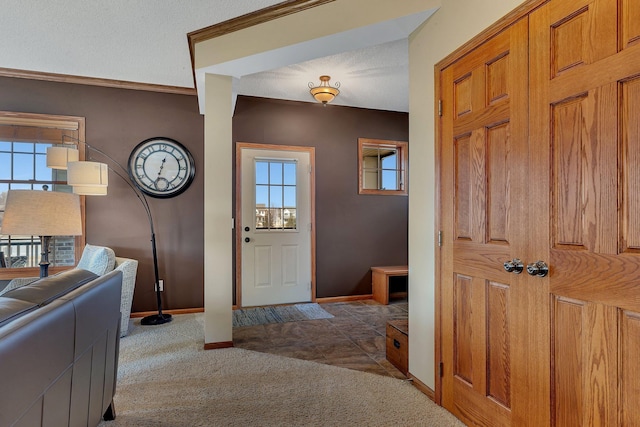 carpeted foyer with a textured ceiling and baseboards