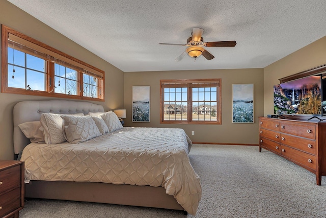 carpeted bedroom with a textured ceiling, baseboards, and a ceiling fan