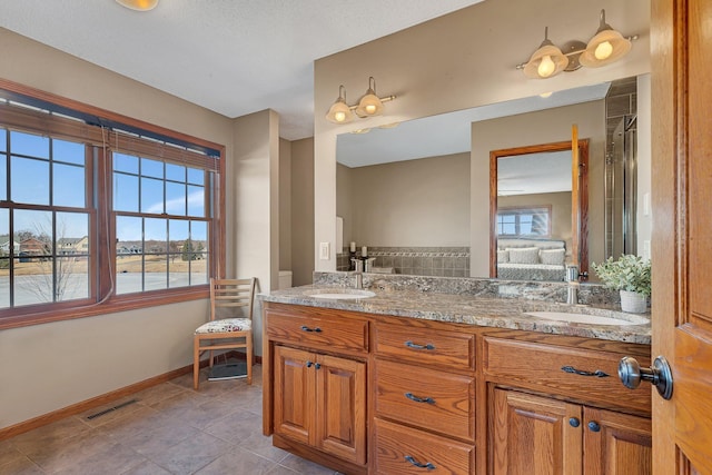 bathroom with baseboards, visible vents, double vanity, a sink, and tile patterned flooring