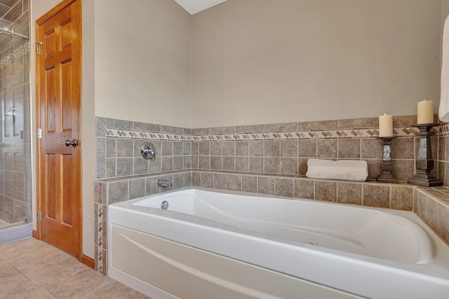 full bath featuring tile patterned floors, a stall shower, and a garden tub