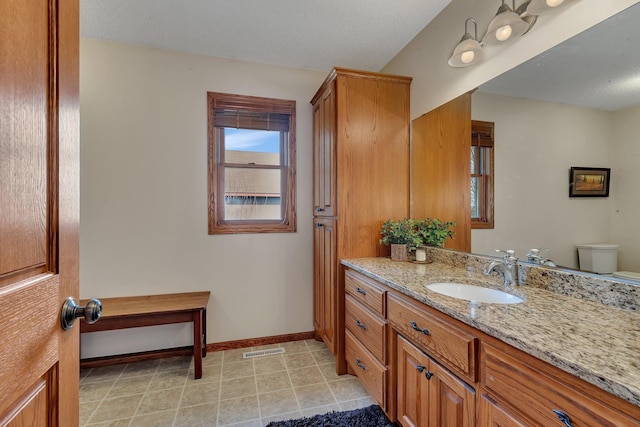 bathroom with tile patterned flooring, visible vents, baseboards, toilet, and vanity