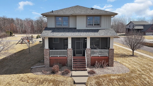 craftsman-style home featuring board and batten siding, covered porch, and roof with shingles