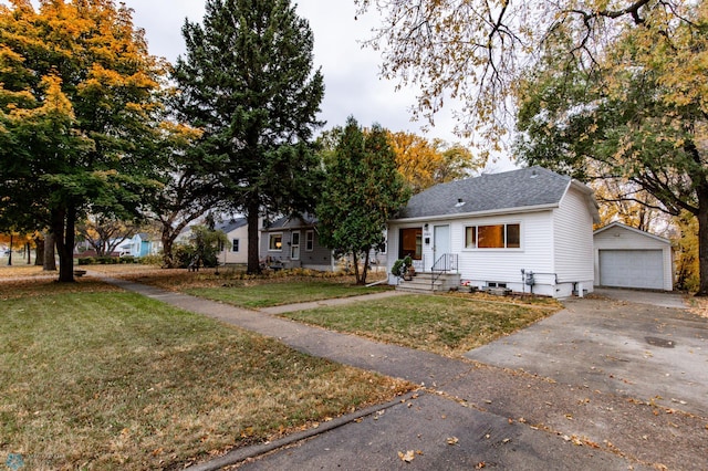 single story home with an outbuilding, a detached garage, driveway, roof with shingles, and a front lawn