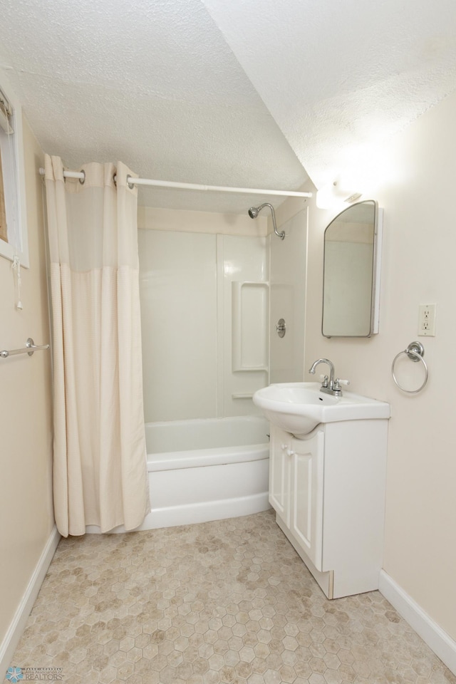 bathroom with a textured ceiling, baseboards, shower / tub combo with curtain, and vanity