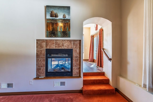 room details featuring carpet floors, baseboards, visible vents, and a tile fireplace