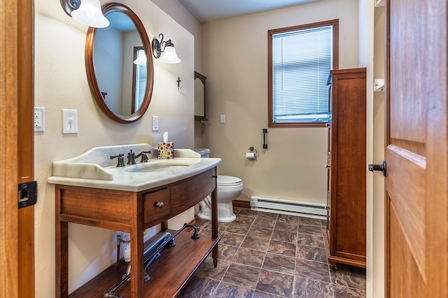 half bathroom featuring a baseboard radiator, vanity, toilet, and baseboards