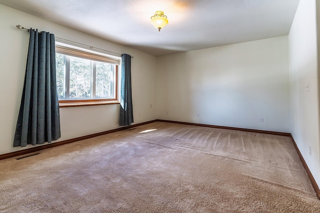 carpeted spare room with baseboards and visible vents