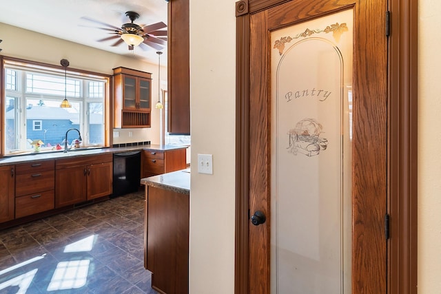 kitchen with ceiling fan, a sink, black dishwasher, brown cabinetry, and decorative light fixtures