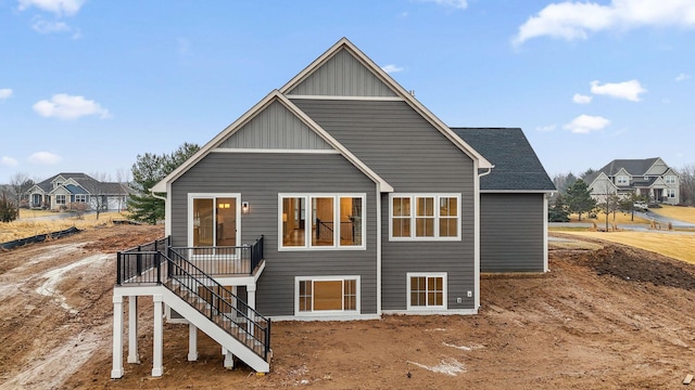 rear view of property featuring stairway and board and batten siding