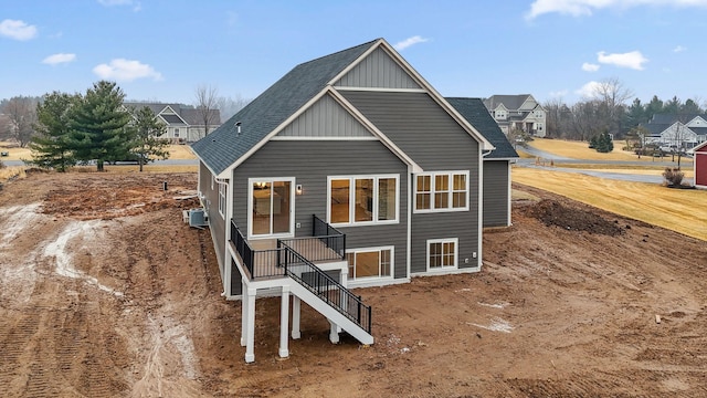 back of house featuring central AC, a shingled roof, and board and batten siding