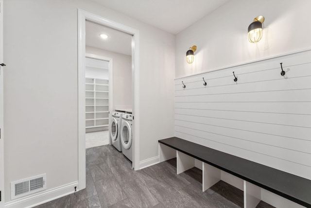 mudroom with baseboards, visible vents, and separate washer and dryer