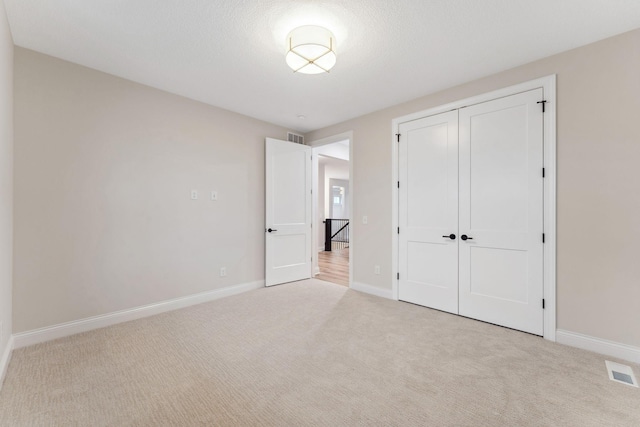 unfurnished bedroom with baseboards, visible vents, and carpet flooring