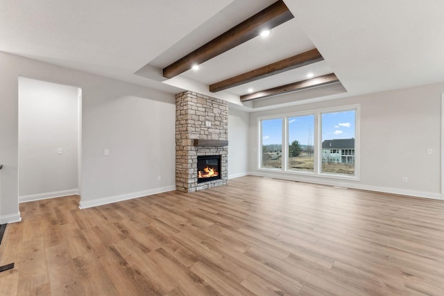 unfurnished living room with light wood-style floors, a fireplace, and baseboards