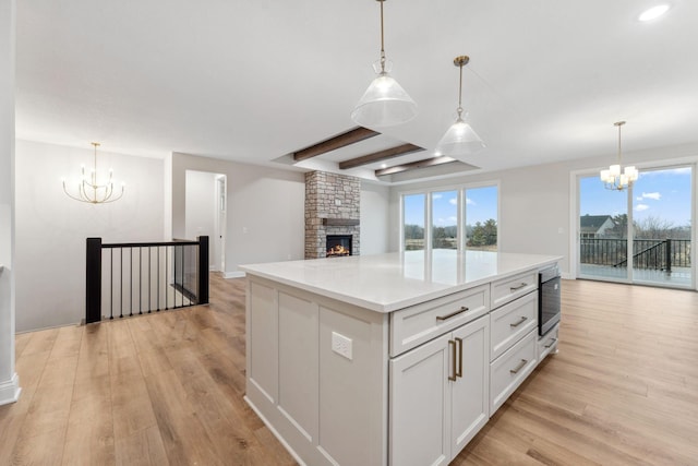 kitchen featuring open floor plan, light countertops, light wood-style flooring, and a notable chandelier