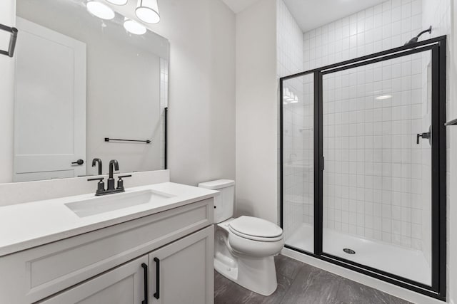 full bath with vanity, a shower stall, and toilet