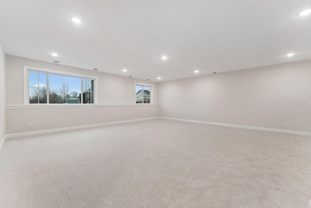 empty room with light carpet, baseboards, and recessed lighting