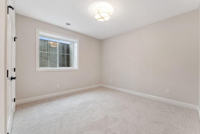 carpeted empty room with baseboards