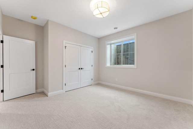 unfurnished bedroom with carpet, baseboards, and a closet