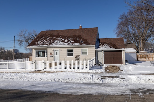 view of front facade with a fenced front yard, a chimney, and a garage