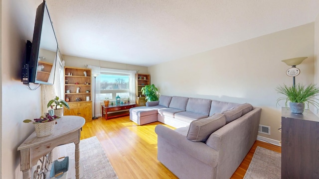 living area with light wood finished floors and visible vents